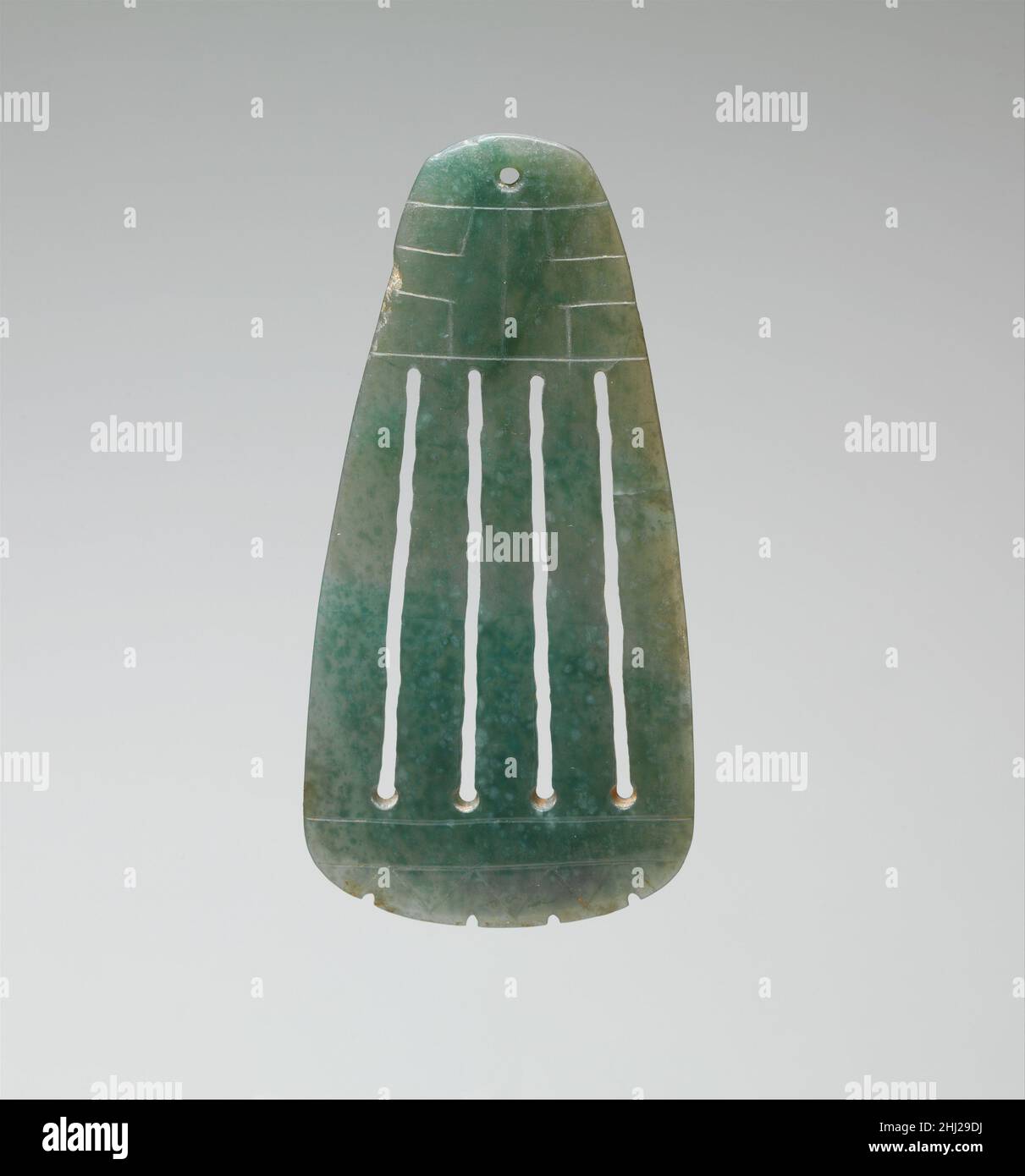 Durchbrochener Anhänger 10th.–4th. Jahrhundert v. Chr. Olmec dieser Jadeanhänger ist mit einem axenähnlichen Profil geschnitzt und zu einer durchsichtigen Plaque verdünnt. Ein gebohrtes Loch an der Oberseite des Anhängers könnte als Teil der Olmec-Ritualregalia verwendet worden sein, um ihn aufzuhängen. Vier parallele Linien verlaufen über die Länge des Anhängers, die durch eine Kombination aus Bohren und Saitensägen hergestellt werden. Ein in der Olmec-Kunst gebräuchliches Motiv mit Kreuzschnitt verweist wahrscheinlich auf die Himmelsrichtungen. Durchbrochener Anhänger 316285 Stockfoto