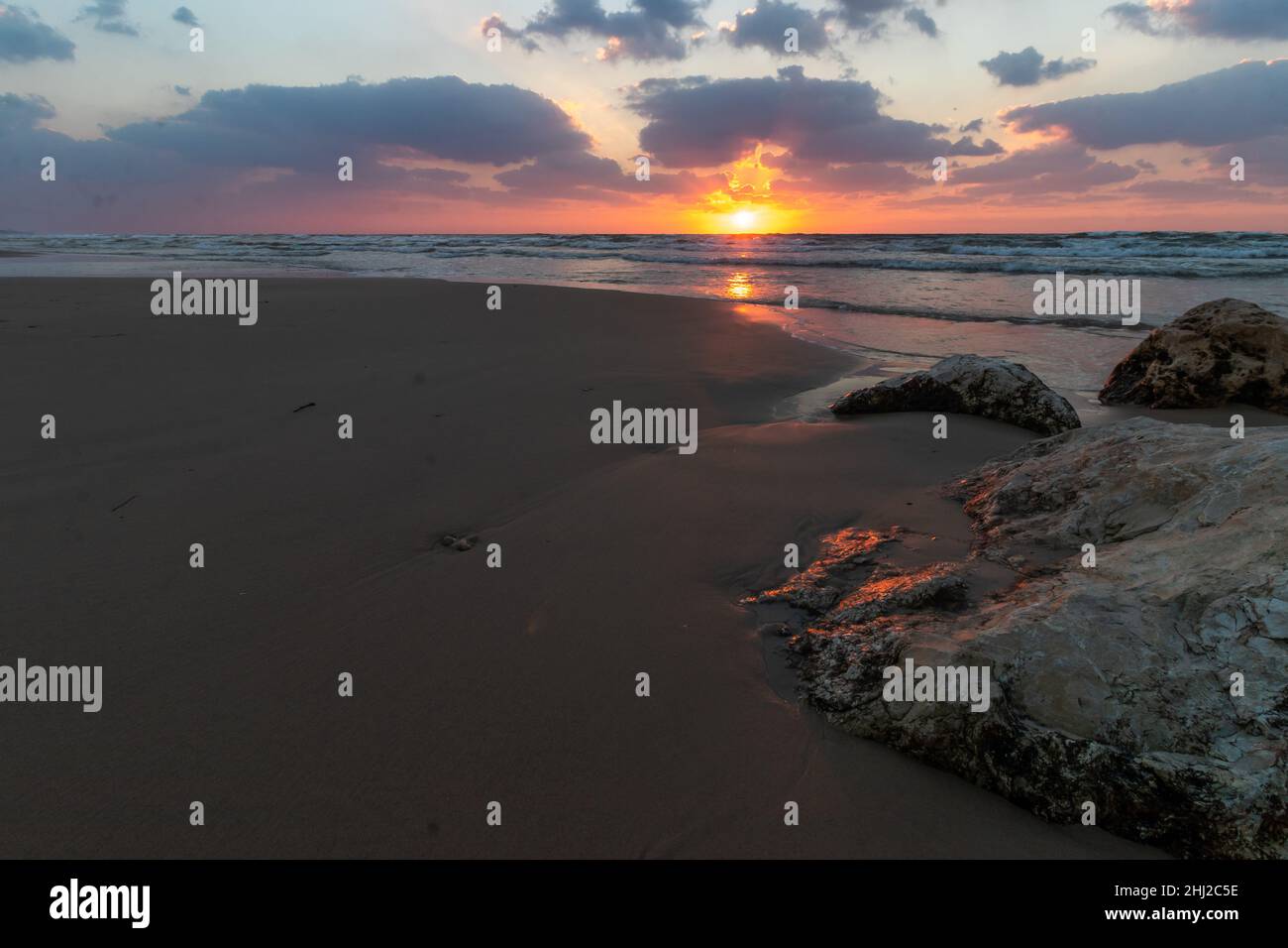 Meer Sonnenuntergang Sand Israel. Low-Angle-Ansicht der roten Sandmuster am Strand bei Sonnenuntergang. Stockfoto