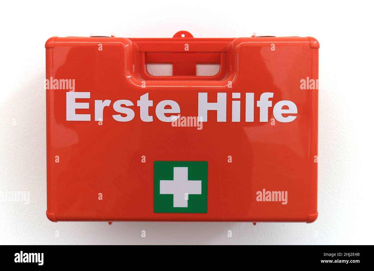 Erste-Hilfe-Kasten an einer weißen Wand mit dem deutschen Text „erste Hilfe“, der in englischer Sprache in „erste Hilfe“ übersetzt wird Stockfoto