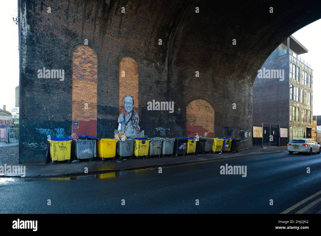 Abfalleimer in einer Linie unter einem Eisenbahnbogen im Bereich der Custard Factory in Digbeth, Birmingham Stockfoto