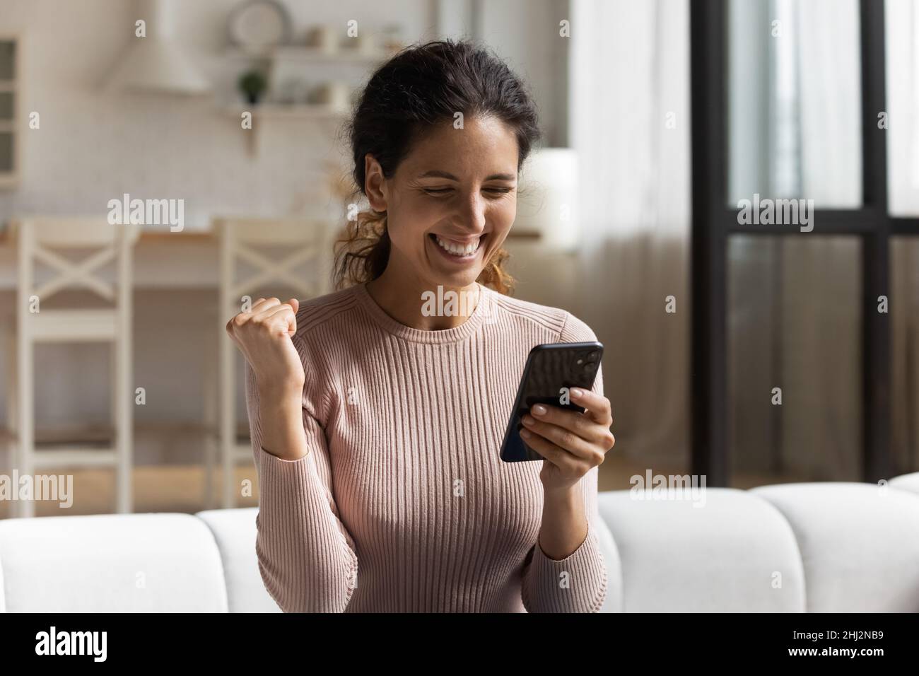 Frau lesen Nachrichten auf Handy fühlt sich glücklich bekam unglaubliches Angebot Stockfoto