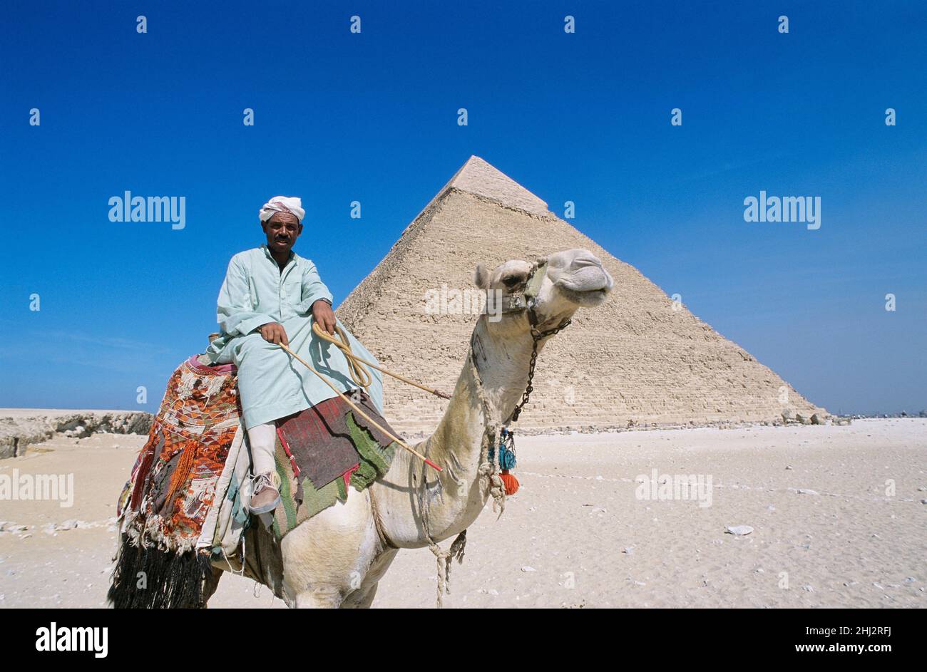 Mann, der ein Kamel vor der Pyramide von Khepre, Gizeh, Ägypten, reitend Stockfoto