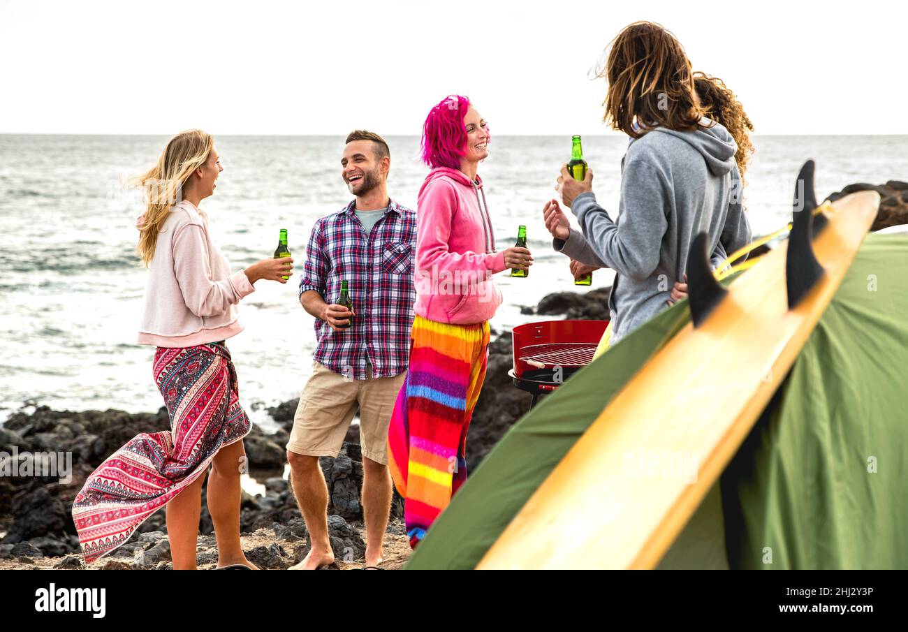 Junge Freunde haben Spaß zusammen auf Strand Camping Party - Reisen Lifestyle-Konzept mit glücklichen Menschen Reisende trinken Flaschenbier bei Sommer Surf Stockfoto