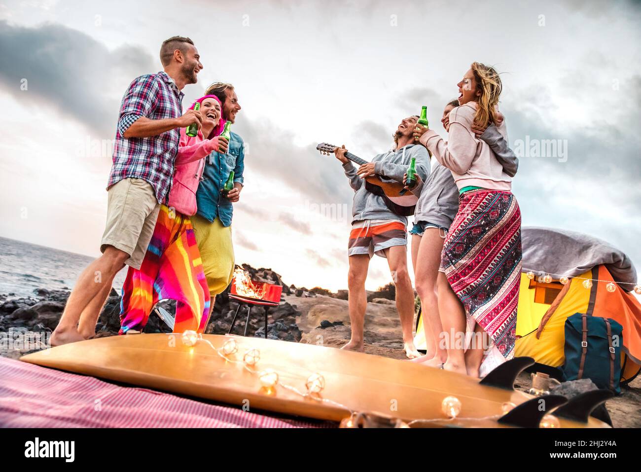 Junge Freunde haben Spaß auf Strand Camping Party - Wanderlust Reise Lifestyle-Konzept mit glücklichen Menschen Reisende jubeln zusammen mit Bier Stockfoto