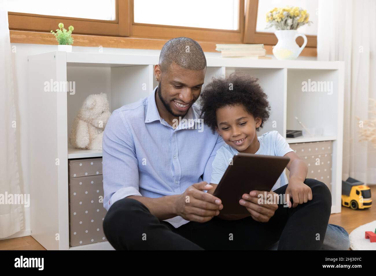 Afrikanischer Vater sein kleiner Sohn, der Spaß mit digitalen Tablet Stockfoto