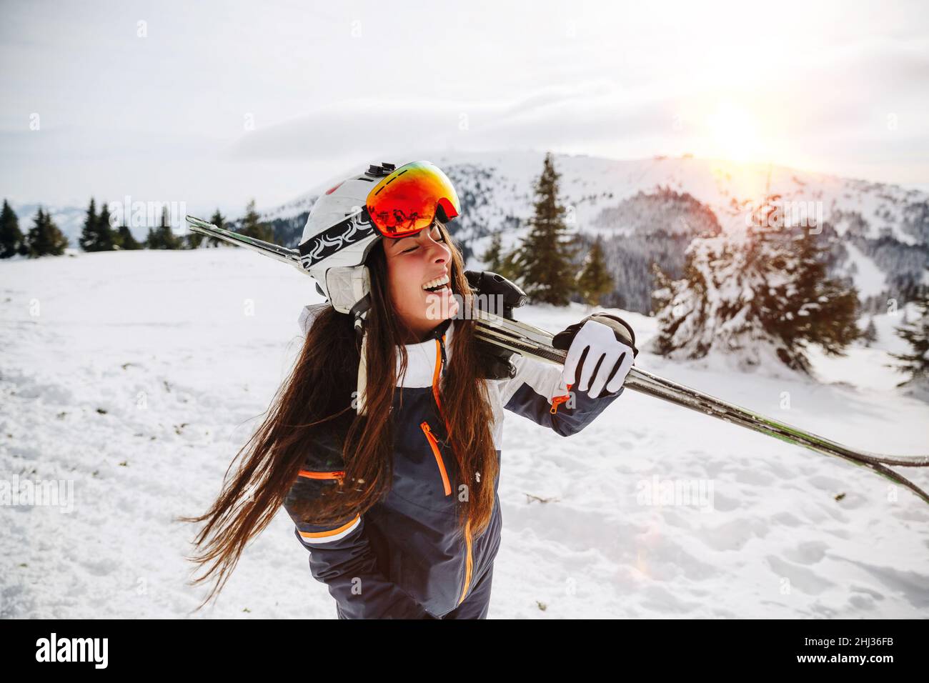 Portrait einer schönen Frau mit Ski und Skianzug im Winterberg Stockfoto