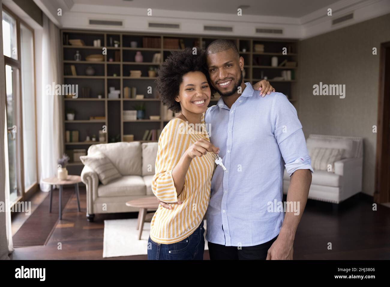 Glückliches afrikanisches Paar, das Schlüssel aus ihrem neuen Haus zeigt Stockfoto