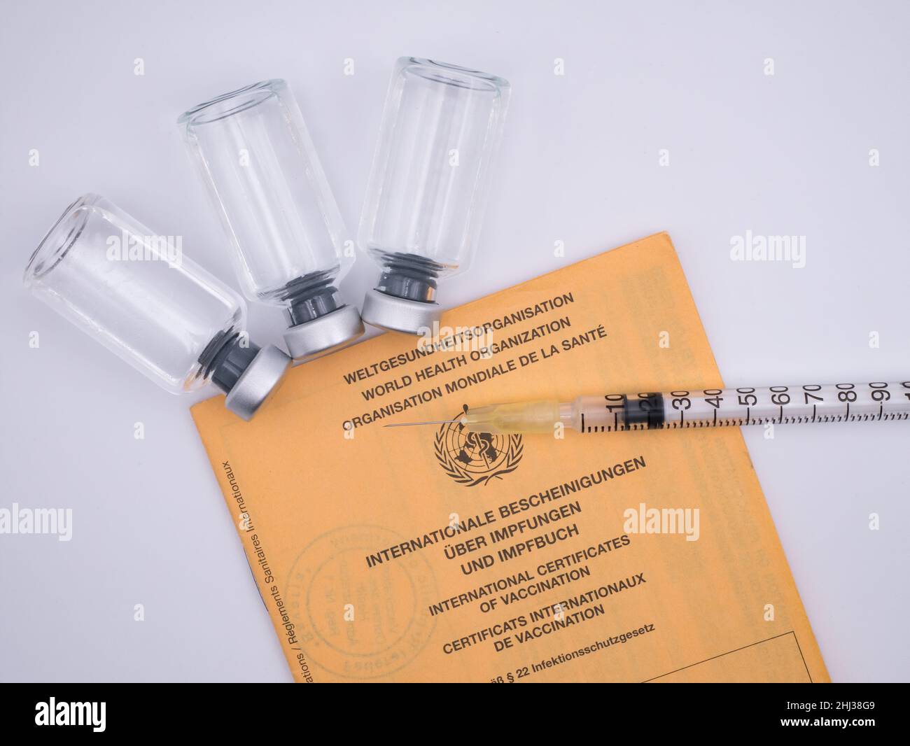 Internationale Impfzertifizierung mit Impfstoffflaschen und Spritze Stockfoto
