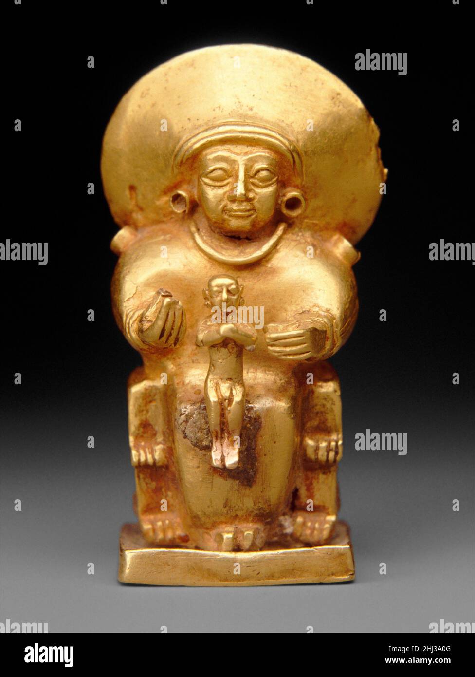 Sitzende Göttin mit einem Kind ca. 14th.–13th. Jahrhundert v. Chr. Hittite dieser kleine Anhänger sollte wahrscheinlich um den Hals als Amulett getragen werden. Kleine Goldfiguren mit Schleifen überleben aus dem Iran, Mesopotamien, der Levante und Ägypten, was die weit verbreitete Verwendung solcher Objekte bestätigt. Ähnliche Objekte aus der hethitischen Kultur deuten darauf hin, dass diese kleinen Figuren tragbare Darstellungen hethitischer Götter waren. Die hier gezeigte, nach dem Wachsausschmelzverfahren in Gold gegossene Figur ist von einer sitzenden Göttin in einem langen Gewand, mit großen ovalen Augen und einem dünnen Mund mit seitlichen Falten. Sie trägt schlichte, geloopte Ohrringe Stockfoto