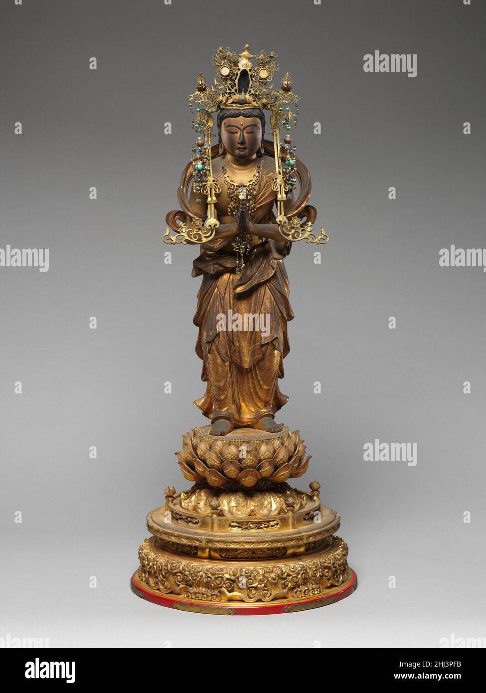 Bodhisattva Seishi 17th. Oder 18th. Jahrhundert Japan Dieses Paar Bodhisattvas (2006,437a–e und .438a–e) war ursprünglich Teil einer skulpturalen Gruppe, die sich auf Amida Buddha (Sanskrit: Amitabha), der das westliche Paradies präsidiert, befass. Seishi (Sanskrit: Mahasthamaprapta), der seine Hände in der Geste der Anbetung hält, stand einst zu Buddhas Recht. Sein Gefährte, Kannon (Sanskrit: Avalokiteshvara), hätte normalerweise einen kleinen Lotussockel gehalten, der einen Thron für die verstorbene Seele darstellt. Die Bodhisattvas haben kleine, sanfte Gesichter mit fleischigen Gesichtszügen und prallen Körpern, die zu einem Androgyno beitragen Stockfoto