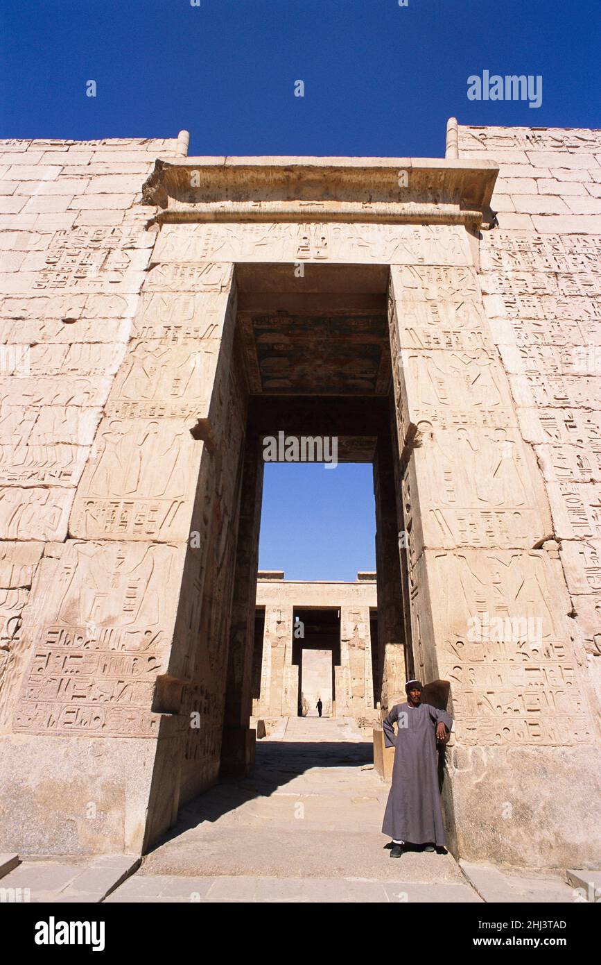 Ägyptischer Mann, der vor dem Tempel von Ramses III, Luxor, Ägypten, steht Stockfoto