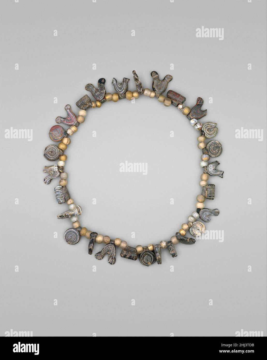 Halskette mit Vogel-, Kreis- und Zylinderperlen 11th–12th Jahrhundert Glasperlen waren beliebte Schmuckelemente in der islamischen Welt. Während einige bunte Glasperlen in Nachahmung von Edelsteinen hergestellt wurden, wurden auch die marmorierten Glasperlen auf dieser Halskette geschätzt und ihre Verwendung war wahrscheinlich nicht auf eine einzige soziale Klasse beschränkt. Halskette mit Vogel-, Kreis- und Zylinderperlen 452510 Stockfoto