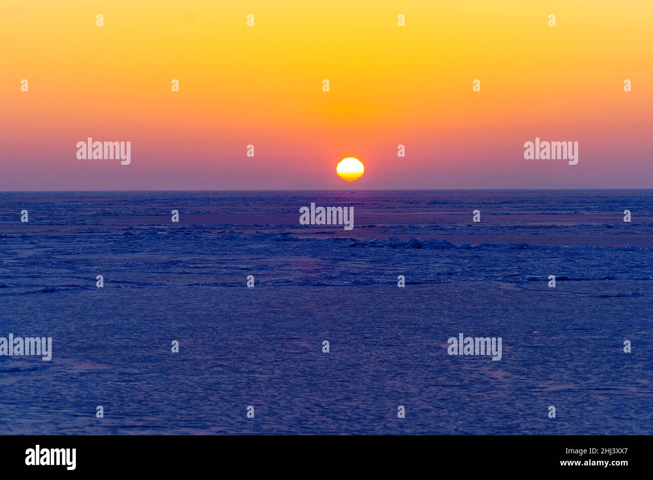 Schöner Sonnenuntergang über der eisigen Oberfläche des Meeres Stockfoto