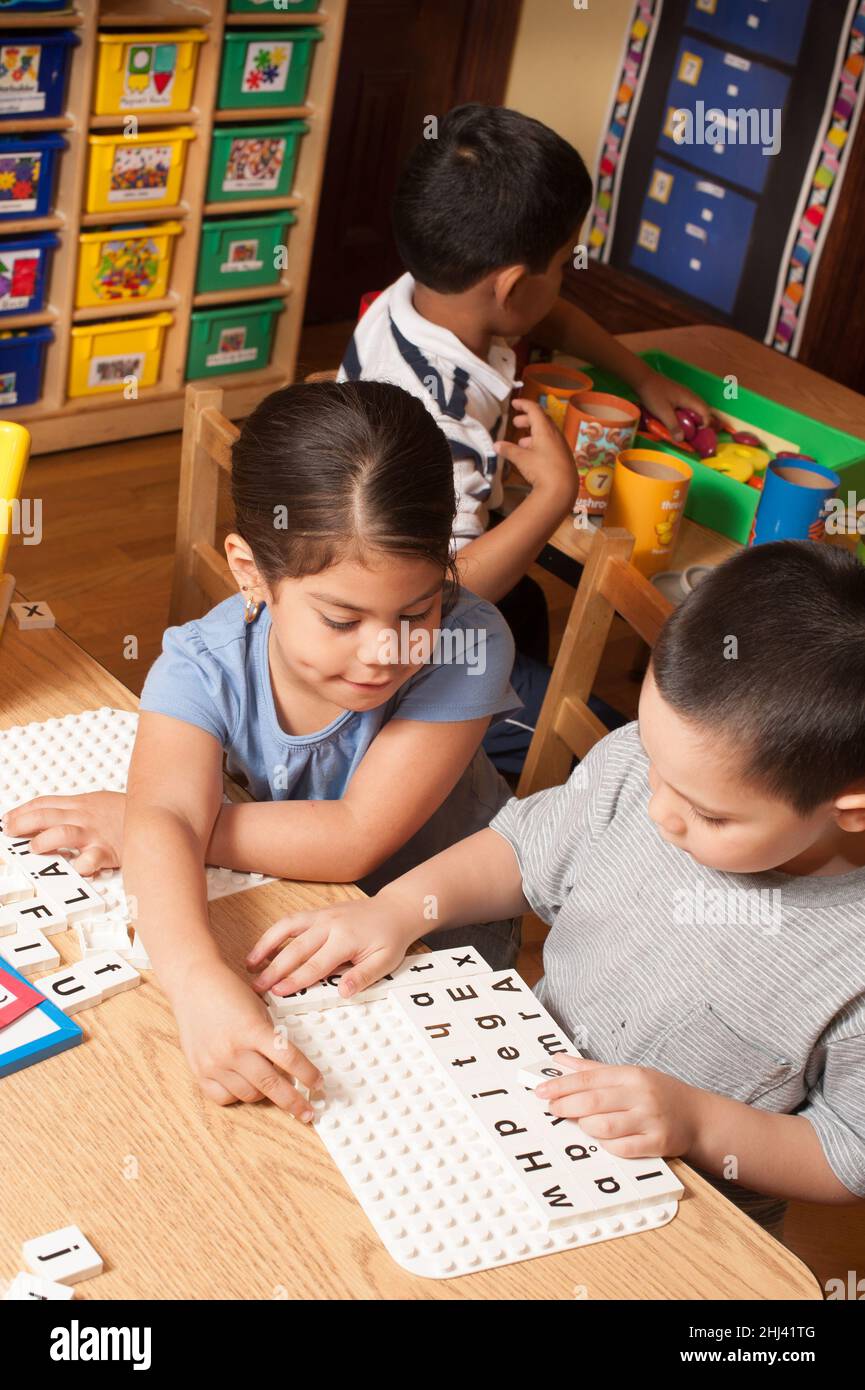 Bildung Vorschule 4-5-jährige Mädchen und Jungen spielen pädagogische Spiel mit Alphabet Buchstaben Stockfoto