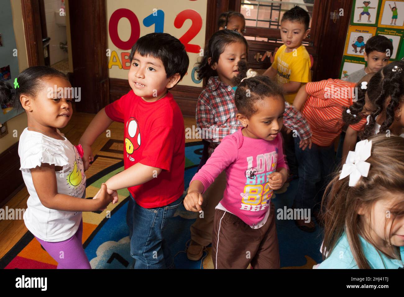 Bildung Vorschule 3-4-jährige Gruppe von Jungen und Mädchen tanzen zu Musik Stockfoto