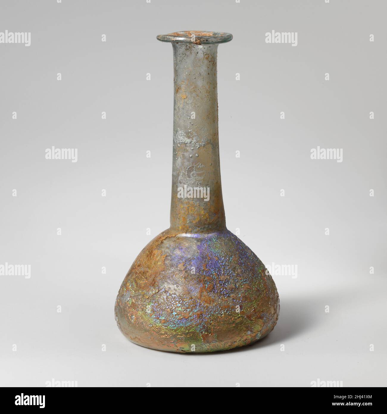 Parfümflasche aus Glas 2nd–3rd Jahrhundert n. Chr. römisch, zypriotisch Durchscheinend blassblaugrün.Röhrenrand ungleichmäßig ausgeklappt, über und in; zylindrischer Hals leicht nach unten ausdehnend, mit horizontaler Werkzeugnut um den Boden; hockiger, bulböser Körper; leicht konkaver Boden.intakt; viele Blasen; Lochfraß und schillernde Verwitterung. Parfümflasche aus Glas 239587 Stockfoto