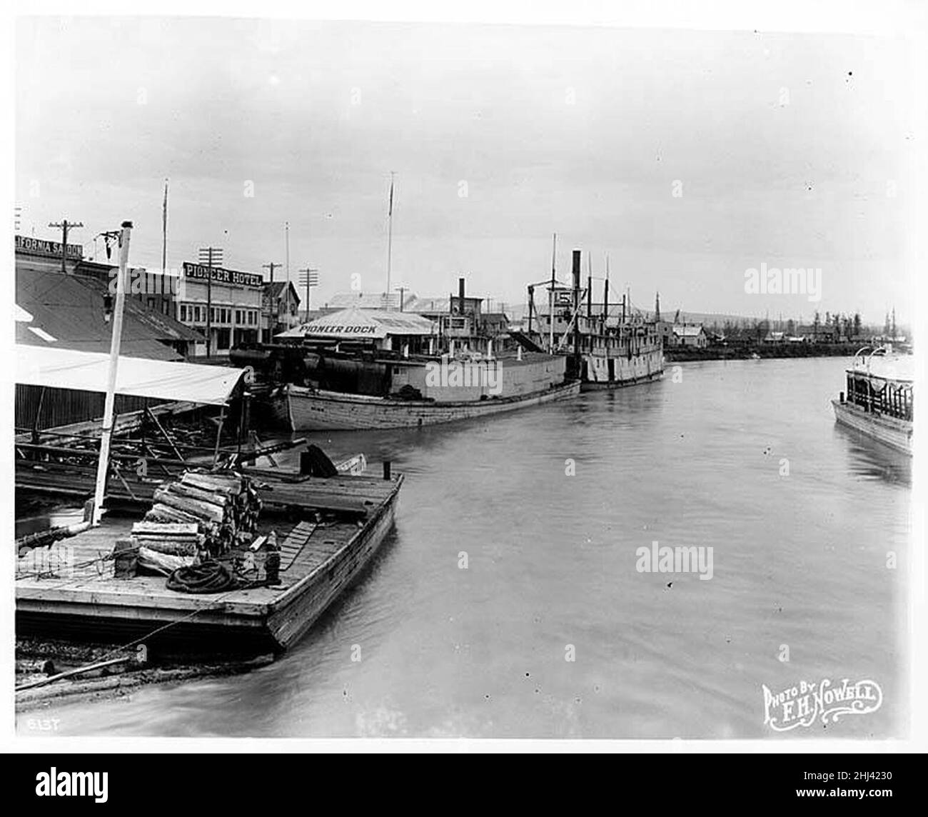 Stern Raddampfer SCHWATKA und Barge MINK am Pioneer Dock in Fairbanks, mit California Saloon und Pioneer Hotel im Hintergrund Stockfoto