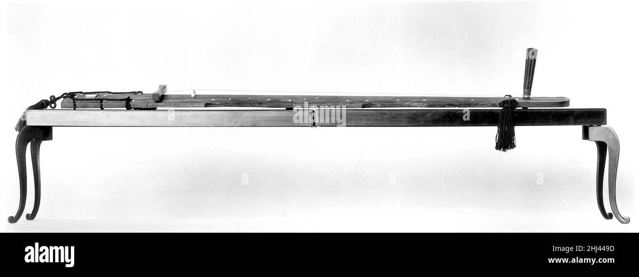 Ichigen-kin (一絃琴) 19th Jahrhundert Kasuke Satake Diese einsaitige Zither wurde wahrscheinlich im 17th Jahrhundert erfunden und blieb bis in die 1920er Jahre populär. Obwohl es eine Wiederbelebung der Tradition gibt, ist das Instrument noch immer selten zu hören. Der Spieler berührt die Seidenschnur leicht mit einem elfenbeinfarbenen Rohr, das am linken Mittelfinger getragen wird. Die Schnur wird mit einem kürzeren, ähnlichen Rohr am rechten Zeigefinger gezupft. Ichigen-kin (一絃琴) 502058 Stockfoto