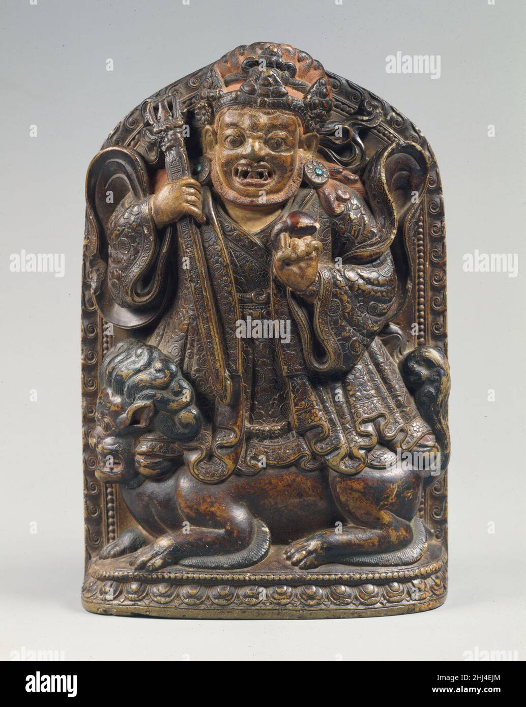Dharmapala steht auf einem Löwen Ca. 16th. Jahrhundert Tibet Dharmapalas, Verteidiger des Dharma, der Lehren des Buddha, repräsentieren eine Kategorie zornvoller Wächter, die für das tibetische System des Buddhismus unerlässlich sind. Sie werden als erleuchtete Wesen verstanden. Dieser furchteinflößende Beschützer steht mit einem ebenso ausdrucksstarken Löwen, der vor spirituellen Gefahren schützt. Dharmapala steht auf einem Löwen 38216 Stockfoto