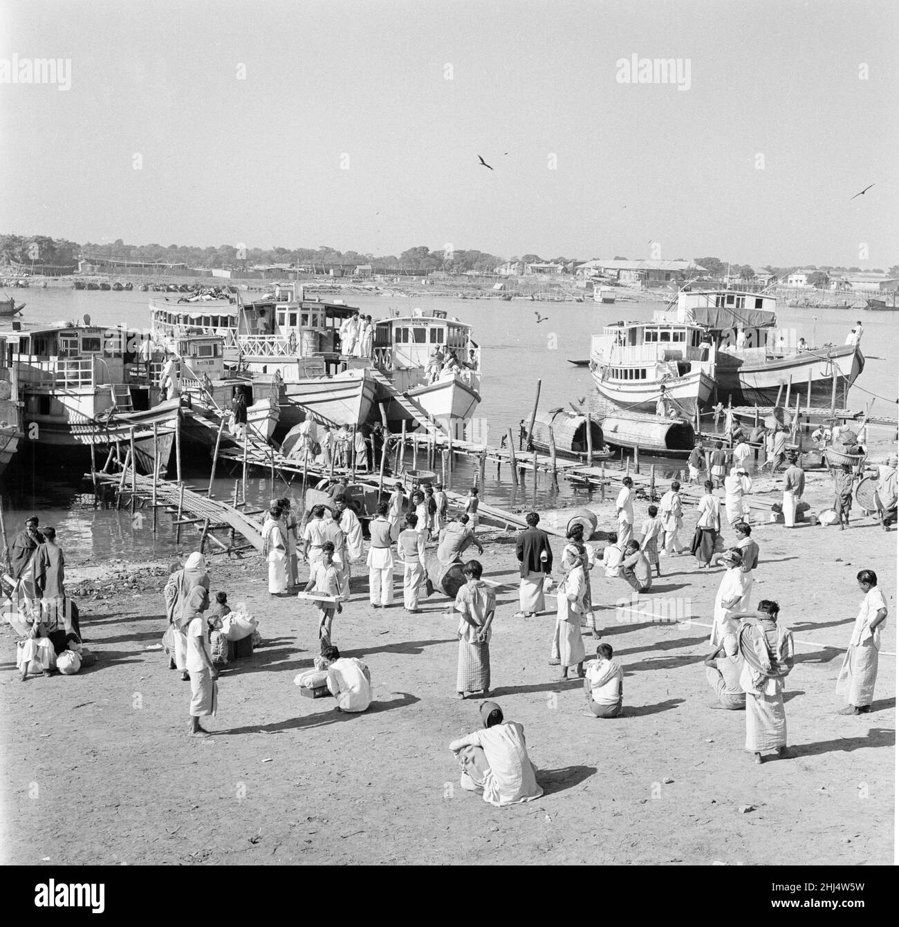 Einheimische warten darauf, an Bord von Fährschiffen zu gehen, die den Hafen in Dacca, Bangladesch, drängen. Februar 1961 l Stockfoto