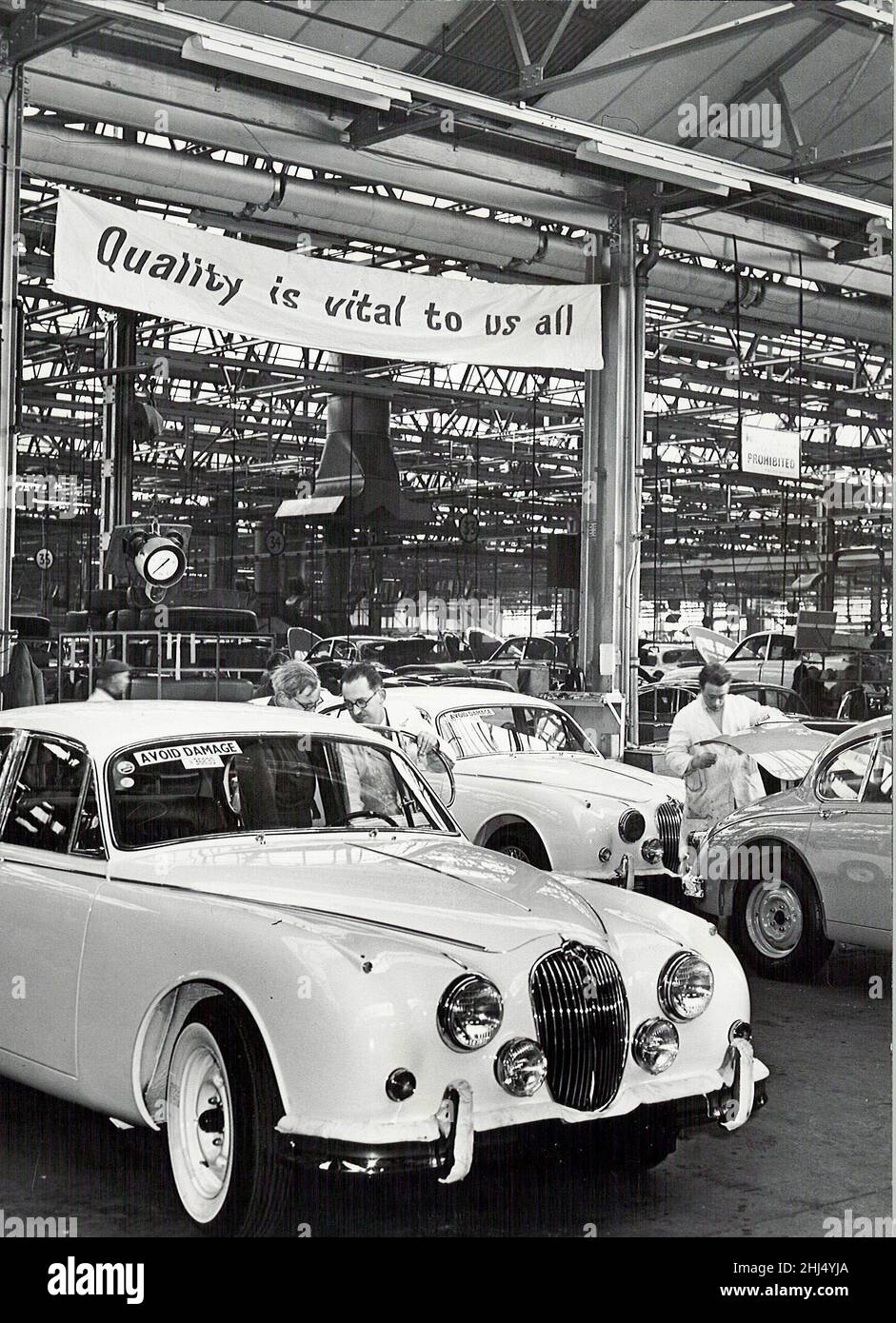 Jaguar Cars Werk, Browns Lane, Coventry. Auf dem Banner über dem Track steht: "Qualität ist für uns alle von entscheidender Bedeutung"11th. Januar 1961 Stockfoto