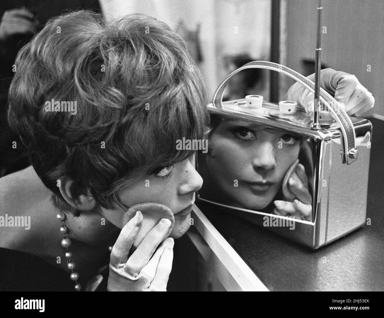 Eine junge Dame nutzt ein verchromtes Radio bei der 1961 National Radio Show, um ihr Make-up zu verjüngen 22nd August 1961 Stockfoto