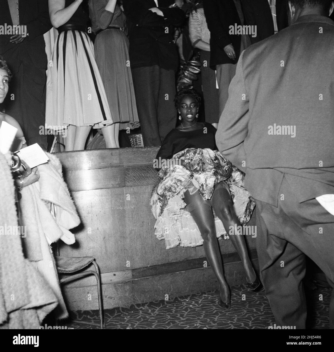 Der erste „Notting Hill Carnival“, der als Reaktion auf die Rassenunruhen im Vorjahr in der Region und den damaligen Stand der Rassenbeziehungen geschaffen wurde. Der von Claudia Jones organisierte Karneval war als karibischer Karneval oder Westindischer Gazette-Karneval bekannt und fand im Rathaus von St. Pancras statt. Erst 1964 würde der Karneval auf die Straßen von Notting Hill ziehen. Bilder zeigen: Einige der Zuschauer, die an der Veranstaltung teilnahmen. 30th. Januar 1959. Stockfoto