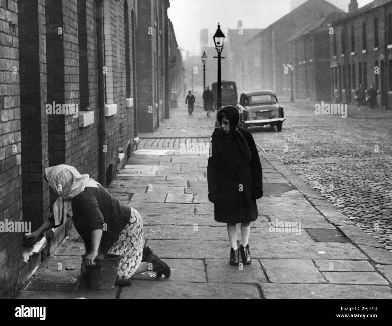 Eine Hausfrau, die die Stufen in der Nelson Street, Manchester, „stonte“. 1st. Dezember 1961 Stockfoto