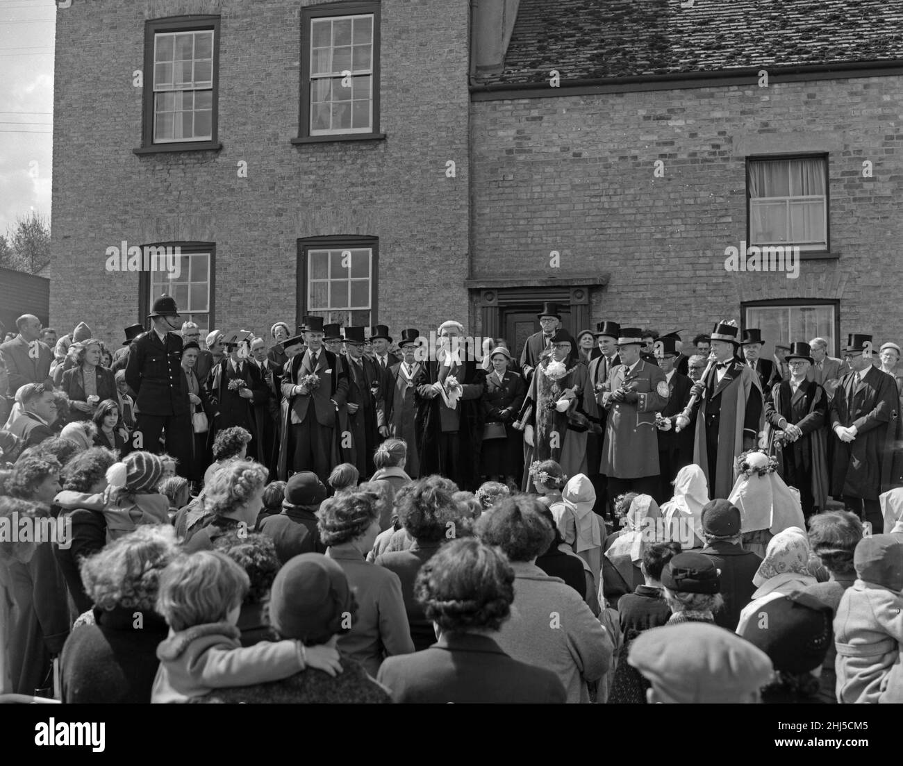 Cambridge-Bürgermeister Leonard D. V. Wordingham wirft den Kindern auf der REACH-Messe, Mai 18th 1959In 1201, Pennys zu King John hat eine Charta für die Abhaltung einer Messe in REACH erteilt. Ursprünglich sollte es am Rogation Monday stattfinden, wurde aber seitdem auf den Anfang Mai stattfindenden Bankfeiertag umgestellt. Nach dem ursprünglichen Brauch wird es vom Bürgermeister von Cambridge in Begleitung der Aldermen in voller Insignie eröffnet Stockfoto