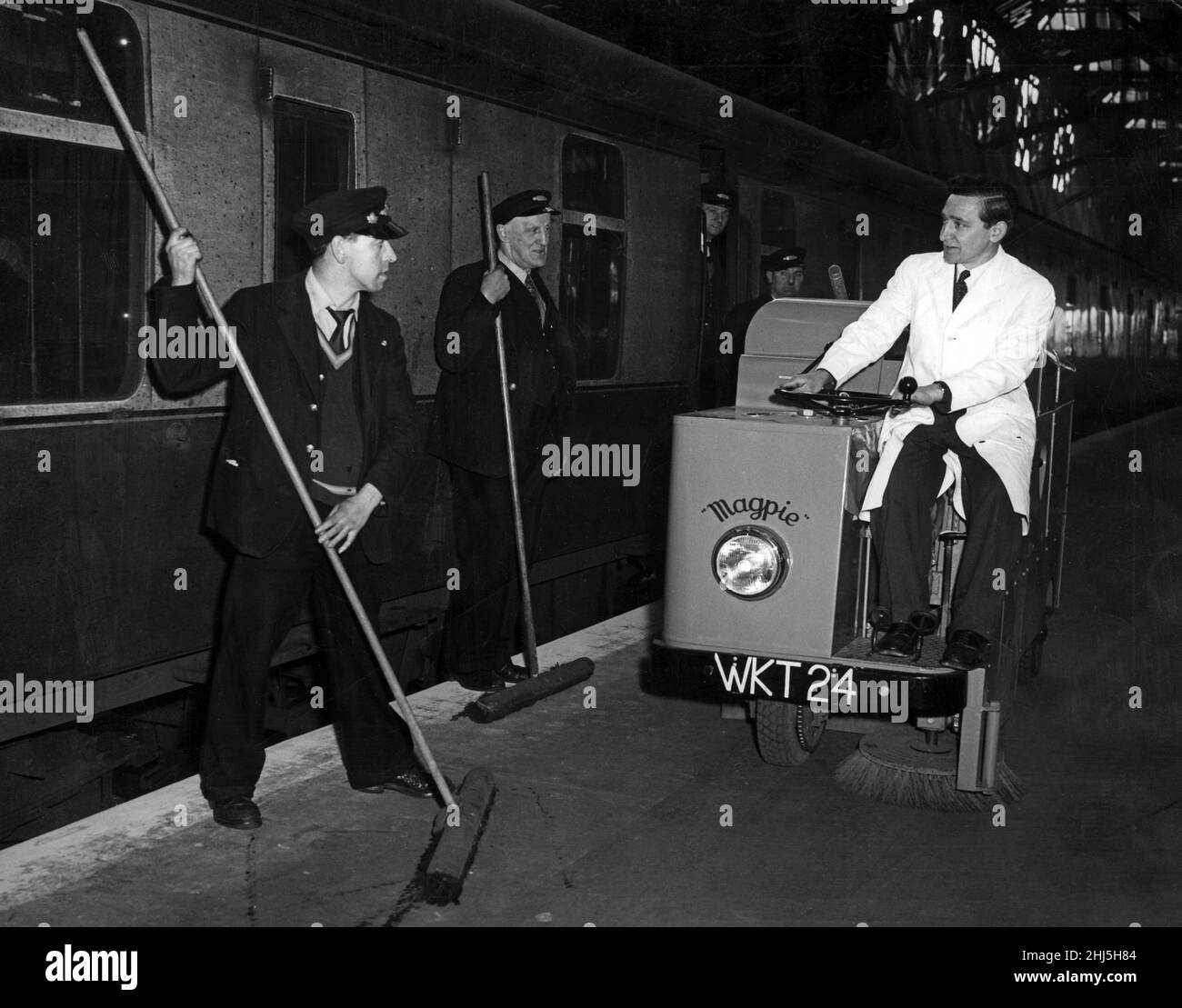 Die mit Besen bewaffneten Portiers John Healy und Robert White halten inne, um sich den neuen Elsterfeger anzusehen, während der Fahrer Alfred Warner im Central Station, Glasgow, vorbeifährt. 16th. April 1956. Stockfoto