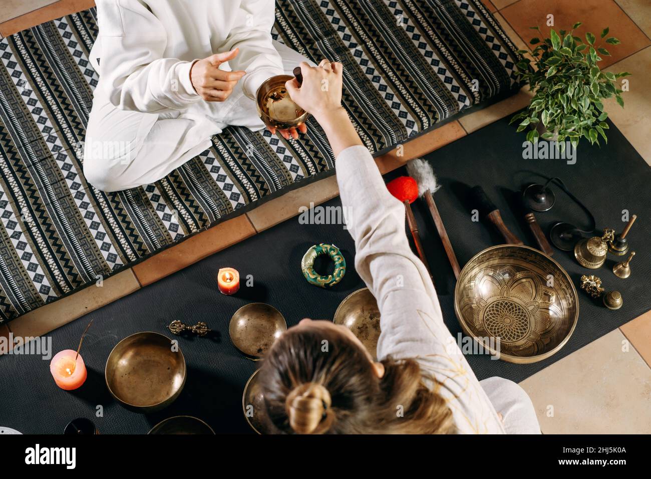 Gesangsschalen Draufsicht, Klangheilung alternative Therapie. Frau spielt auf Percussion Metal Musikinstrumenten. Psychische Gesundheit mit Meditation Stockfoto