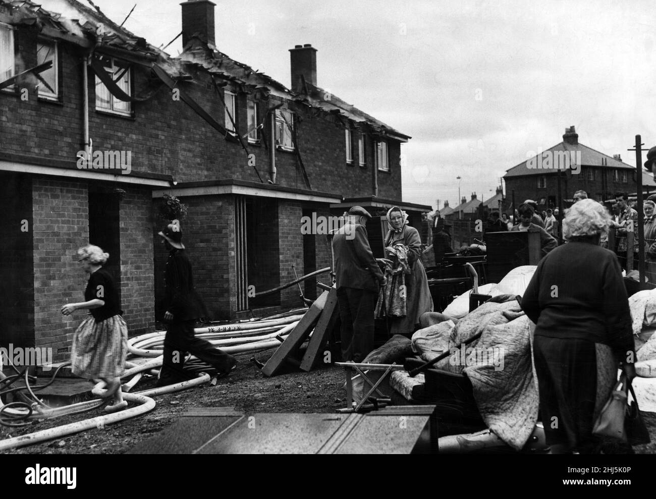 Nach einem Brand an der Kenton Road, Coxlodge, sammeln sich die Nachbarn, um den betroffenen Mietern bei der Bergung ihres Besitzes zu helfen. 26th. Juli 1961. Stockfoto