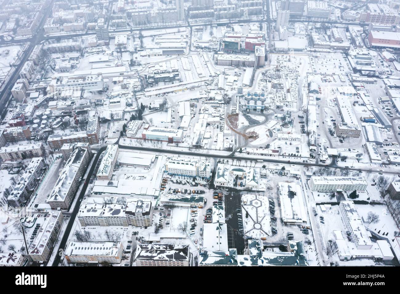 Städtisches Industriegebiet, bedeckt von Schnee an einem nebligen Wintertag. Vogelaugen. Stockfoto