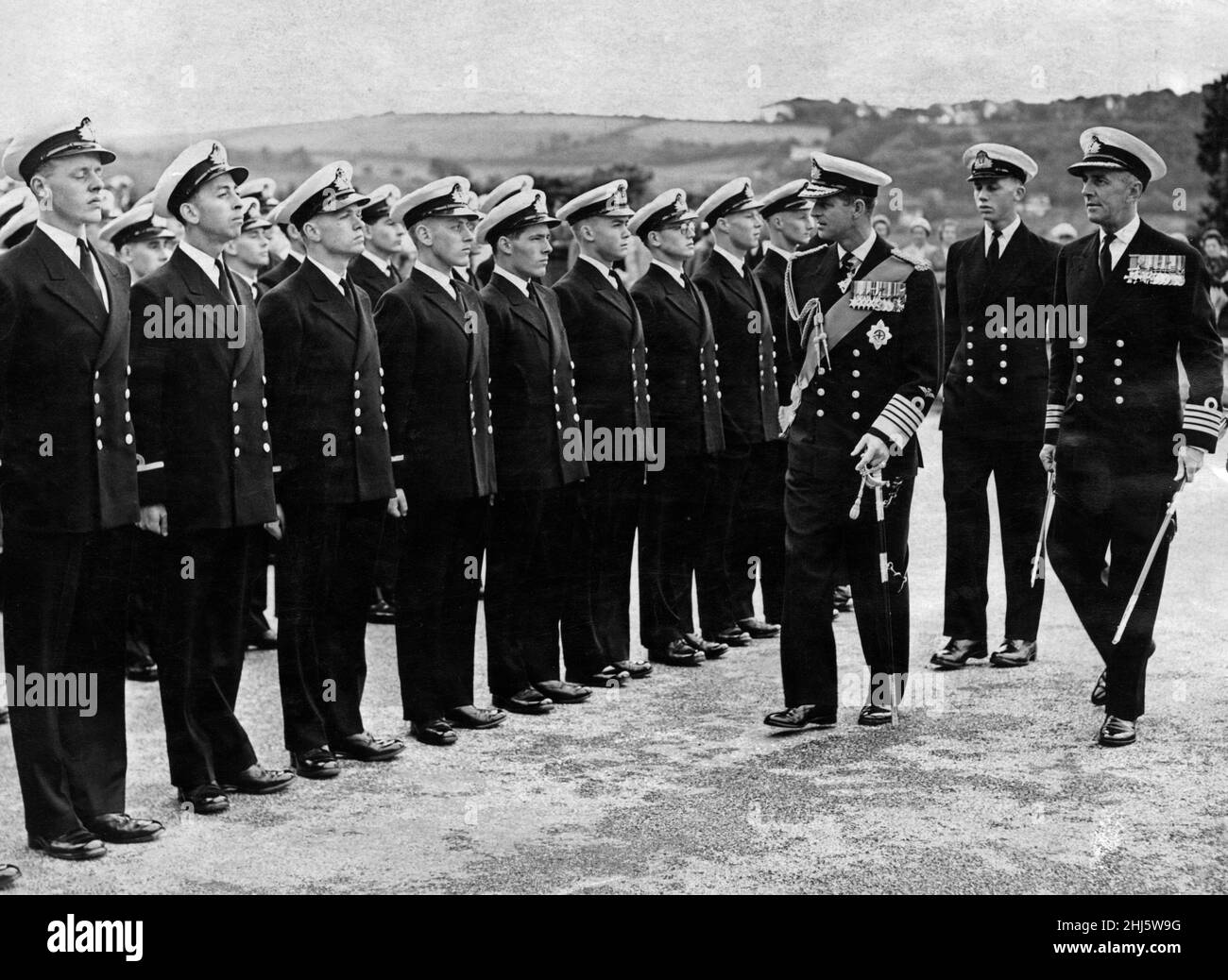 Der Herzog von Edinburgh präsentiert die Farbe der Königin dem Britannia Royal Naval College in Dartmouth, Devon. Die Königin konnte nicht teilnehmen, weil es ihr nicht gut ging. Der Herzog inspiziert in Begleitung des Hauptmanns des Kollegiums, Capt W.J Munn, die Reihen während der Passanten-Parade. 1st. Juli 1958. Stockfoto