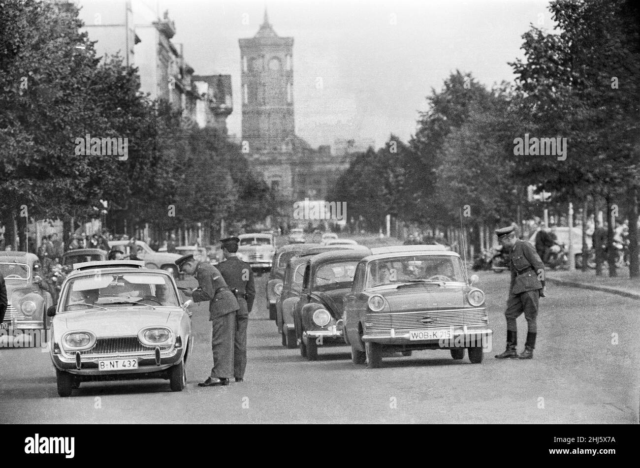 Beginn des Baus der Berliner Mauer.am 13th. August um Mitternacht begannen Polizei und Einheiten der DDR-Armee mit der Schließung der Grenze und am Sonntagmorgen, dem 13. August, wurde die Grenze zu West-Berlin geschlossen. Ostdeutsche Truppen und Arbeiter hatten begonnen, Straßen entlang der Grenze zu zerreißen, um sie für die meisten Fahrzeuge unpassierbar zu machen und Stacheldraht-Verstrickungen und Zäune entlang der 156 Kilometer um die drei westlichen Sektoren sowie der 43 Kilometer, die West und Ost trennten, zu installieren Berlin. Das Bild zeigt: Die DDR-Polizei überprüft die Fahrerdokumentation auf der St. Stockfoto