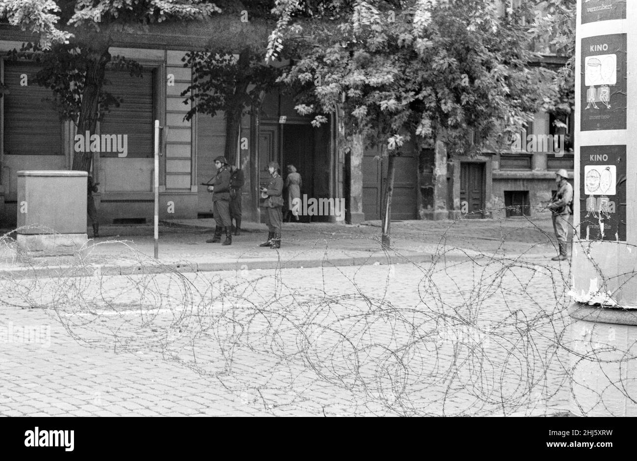 Beginn des Baus der Berliner Mauer.am 13th. August um Mitternacht begannen Polizei und Einheiten der DDR-Armee mit der Schließung der Grenze und am Sonntagmorgen, dem 13. August, wurde die Grenze zu West-Berlin geschlossen. Ostdeutsche Truppen und Arbeiter hatten begonnen, Straßen entlang der Grenze zu zerreißen, um sie für die meisten Fahrzeuge unpassierbar zu machen und Stacheldraht-Verstrickungen und Zäune entlang der 156 Kilometer um die drei westlichen Sektoren sowie der 43 Kilometer, die West und Ost trennten, zu installieren Berlin. Bild zeigt: DDR-Soldaten wachen auf den Straßen Berlins Stockfoto