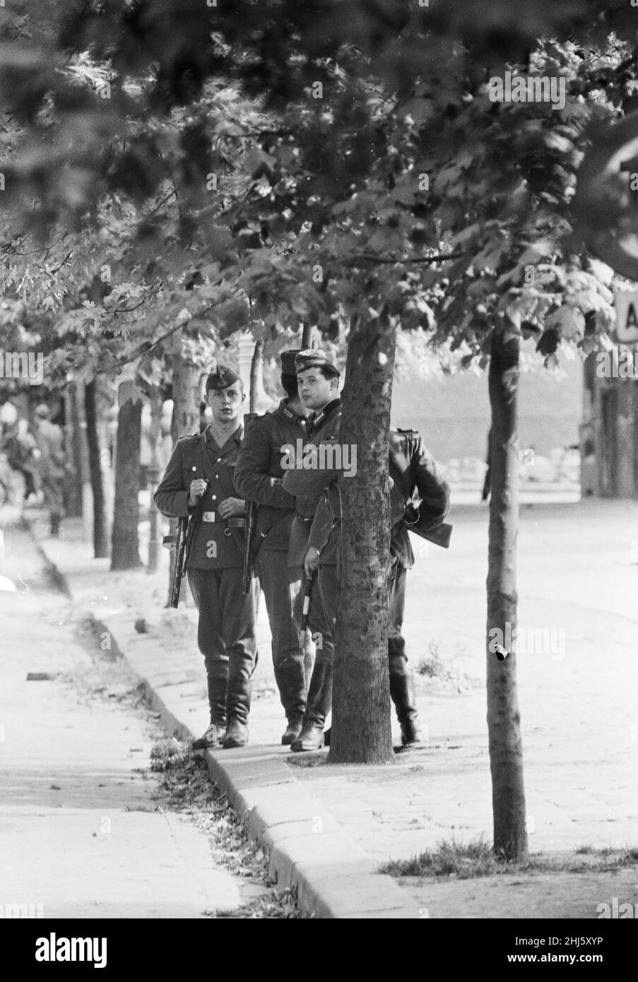 Beginn des Baus der Berliner Mauer.am 13th. August um Mitternacht begannen Polizei und Einheiten der DDR-Armee mit der Schließung der Grenze und am Sonntagmorgen, dem 13. August, wurde die Grenze zu West-Berlin geschlossen. Ostdeutsche Truppen und Arbeiter hatten begonnen, Straßen entlang der Grenze zu zerreißen, um sie für die meisten Fahrzeuge unpassierbar zu machen und Stacheldraht-Verstrickungen und Zäune entlang der 156 Kilometer um die drei westlichen Sektoren sowie der 43 Kilometer, die West und Ost trennten, zu installieren Berlin. Bild zeigt: DDR-Grenzposten wachen auf den Straßen von Berl Stockfoto