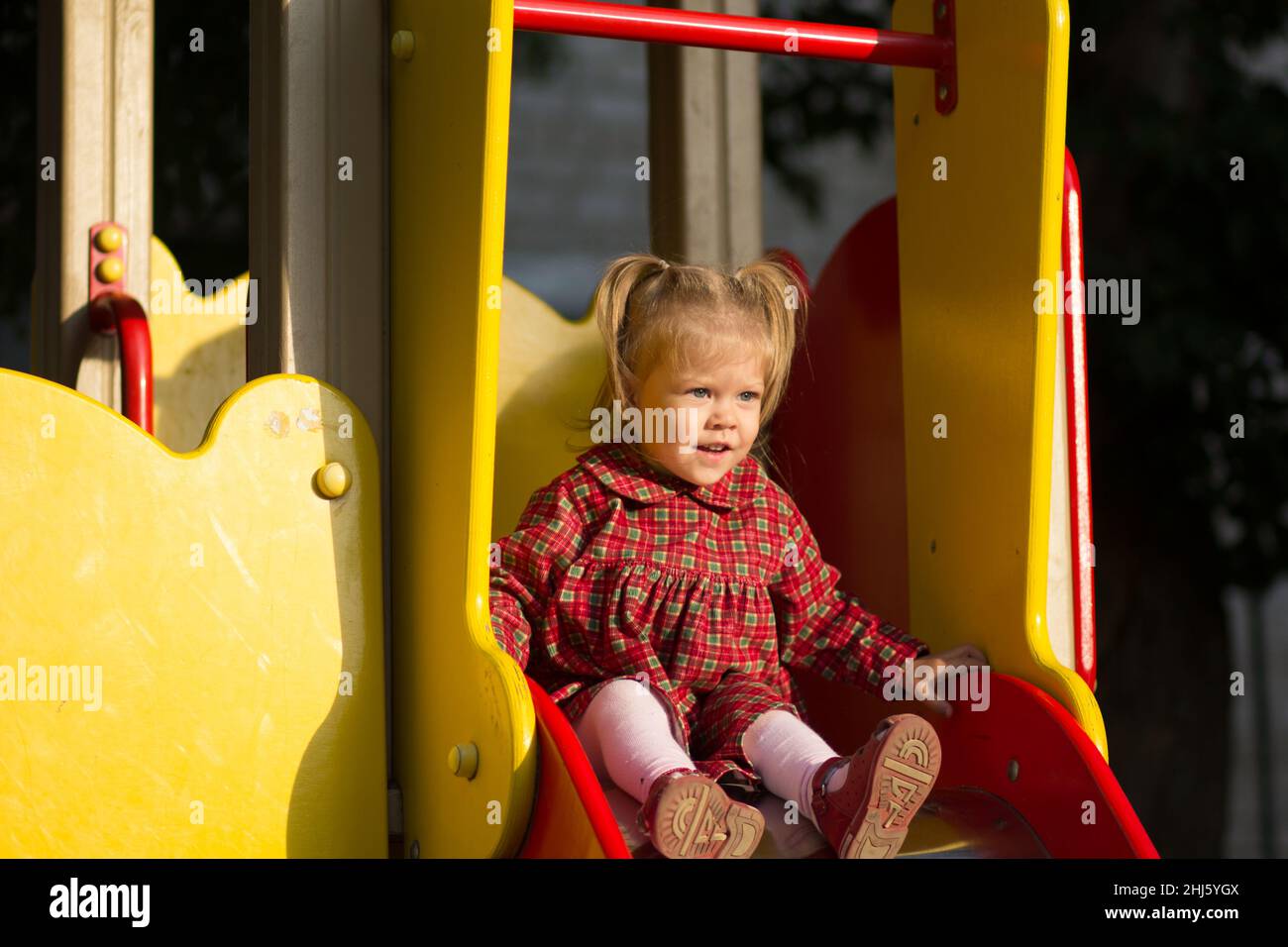 Glücklich in Versuchung kaukasisches Kind von zwei Jahren vor dem Rutschen auf dem Spielplatz Stockfoto