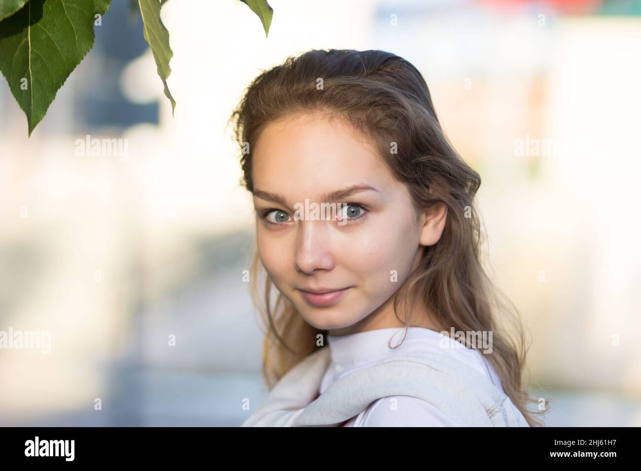 Porträt einer jungen kaukasischen Frau im Sommerpark, die mit prall gefüllten Augen auf die Kamera schaut Stockfoto