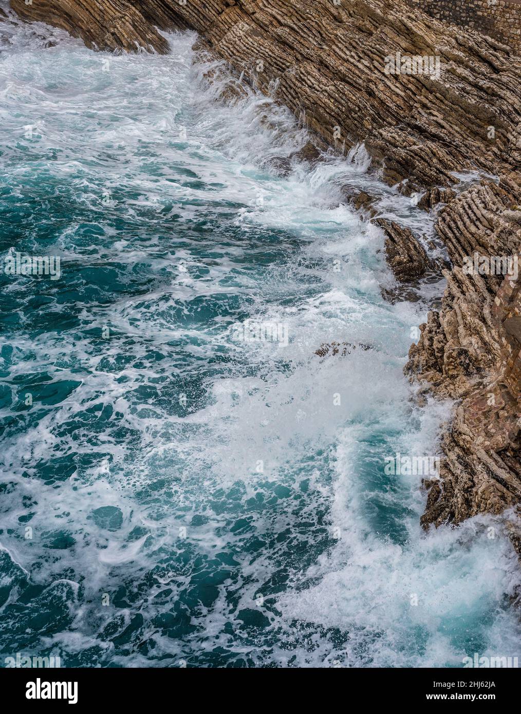 Dramatischer Meereshintergrund. Felsküste der Adria. Weiße, schäumende Wellen schlagen gegen das steinerne Ufer. Panorama der Küste. Luftaufnahme von oben. Adria Stockfoto
