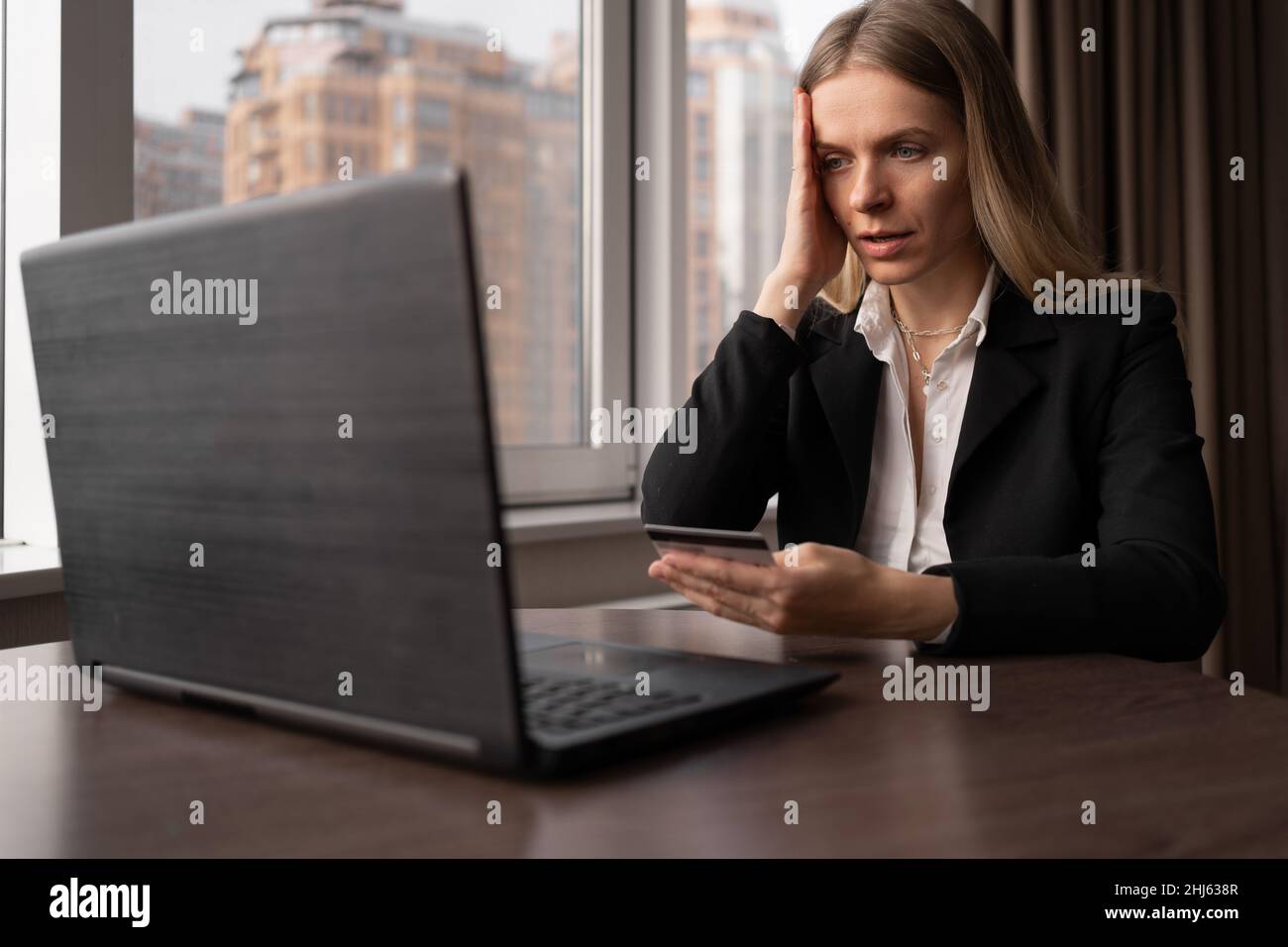 Online-Shopping-Konzept. Verärgert Frau mit Kreditkarte und Laptop im Büro, Online-Shopping und Finanzbetrug, Bestellung und Zahlung per Karte Stockfoto