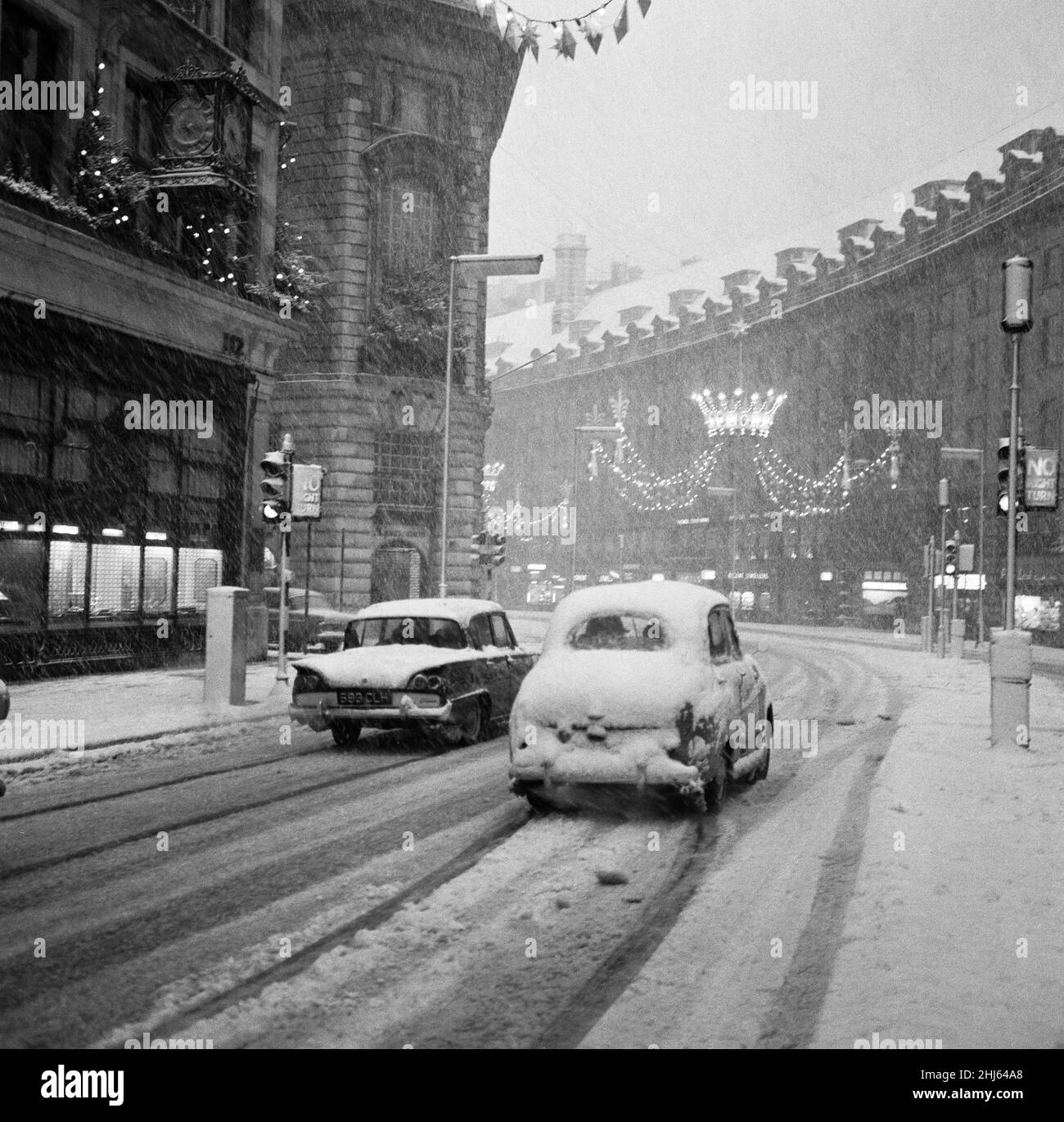 Der heftige Schneefall an Silvester verlässt die Londoner Regent Street in der Nähe menschenleerer Käufer, während die wenigen Autos, die sich auf unbehandelten Straßen wagen, kämpfen. 31st. Dezember 1961 Stockfoto