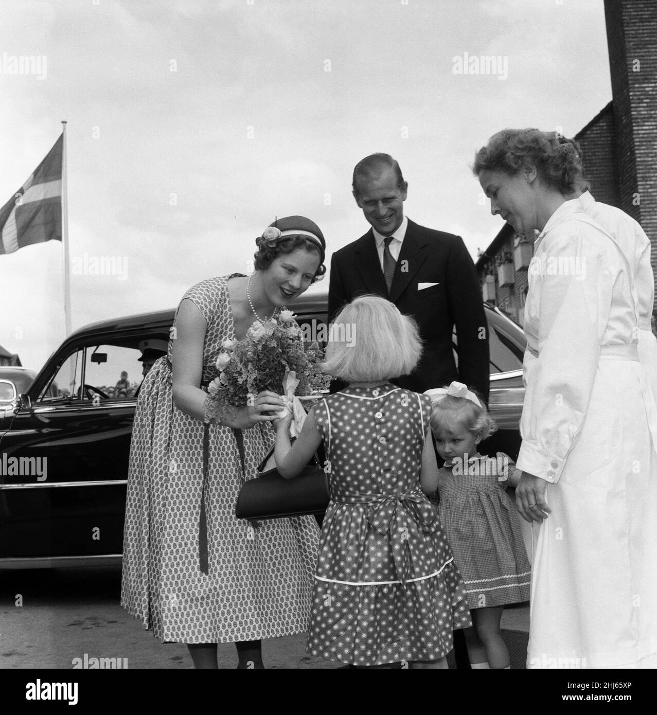 Königin Elizabeth II. Und Prinz Philip, Herzog von Edinburgh, besuchen Dänemark. Prinzessin Margrethe (zukünftige Königin von Dänemark) mit Prinz Philip erhielt einen Blumenstrauß von einem Kind, als die königliche Partei das städtische Erholungszentrum von Kopenhagen besuchte. 22nd Mai 1957. Stockfoto