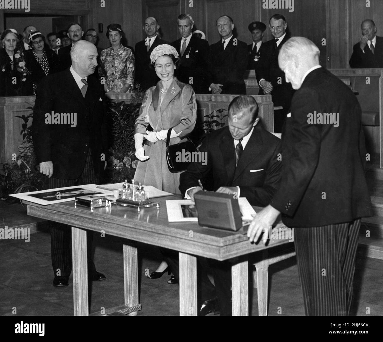 Königin Elizabeth II. Und Prinz Philip, Herzog von Edinburgh, zu Besuch in Chester. Der Herzog von Edinburgh signiert sein Porträt während des Besuchs in Chester's neuer County Hall. Die Königin hatte ihr Porträt unterzeichnet, musste aber einige Augenblicke warten, bis der Herzog seine Unterschrift vollzog. Juli 1957. Stockfoto
