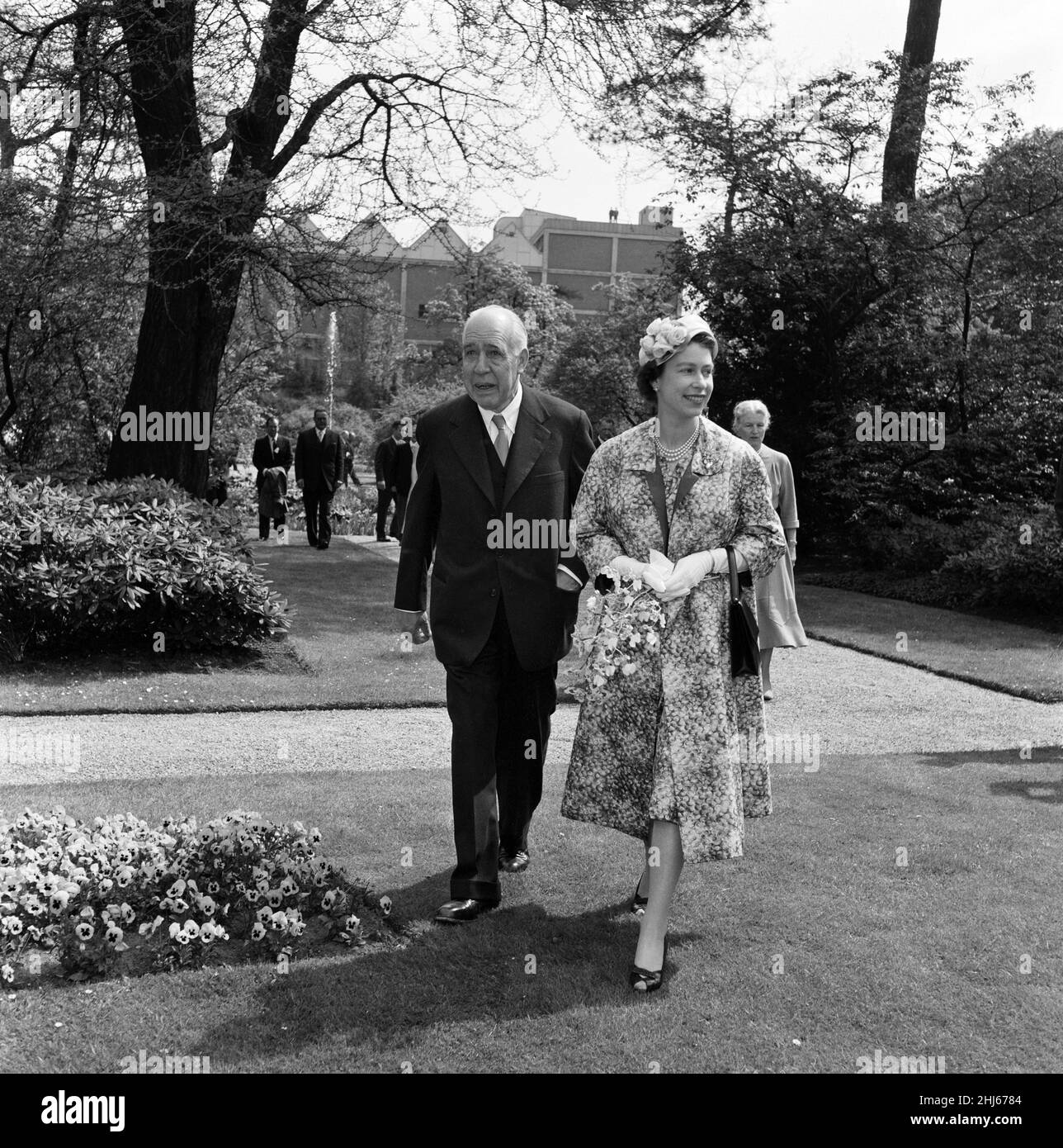 Königin Elizabeth II. Und Prinz Philip, Herzog von Edinburgh, besuchen Dänemark. Die Königin im fröhlich gemusterten Mantel und passenden Kleid geht mit dem bedeutenden dänischen Nuklearphysiker Professor Niels Bohr in seiner Residenz in den Carlsberg Breweries spazieren. 22nd Mai 1957. Stockfoto