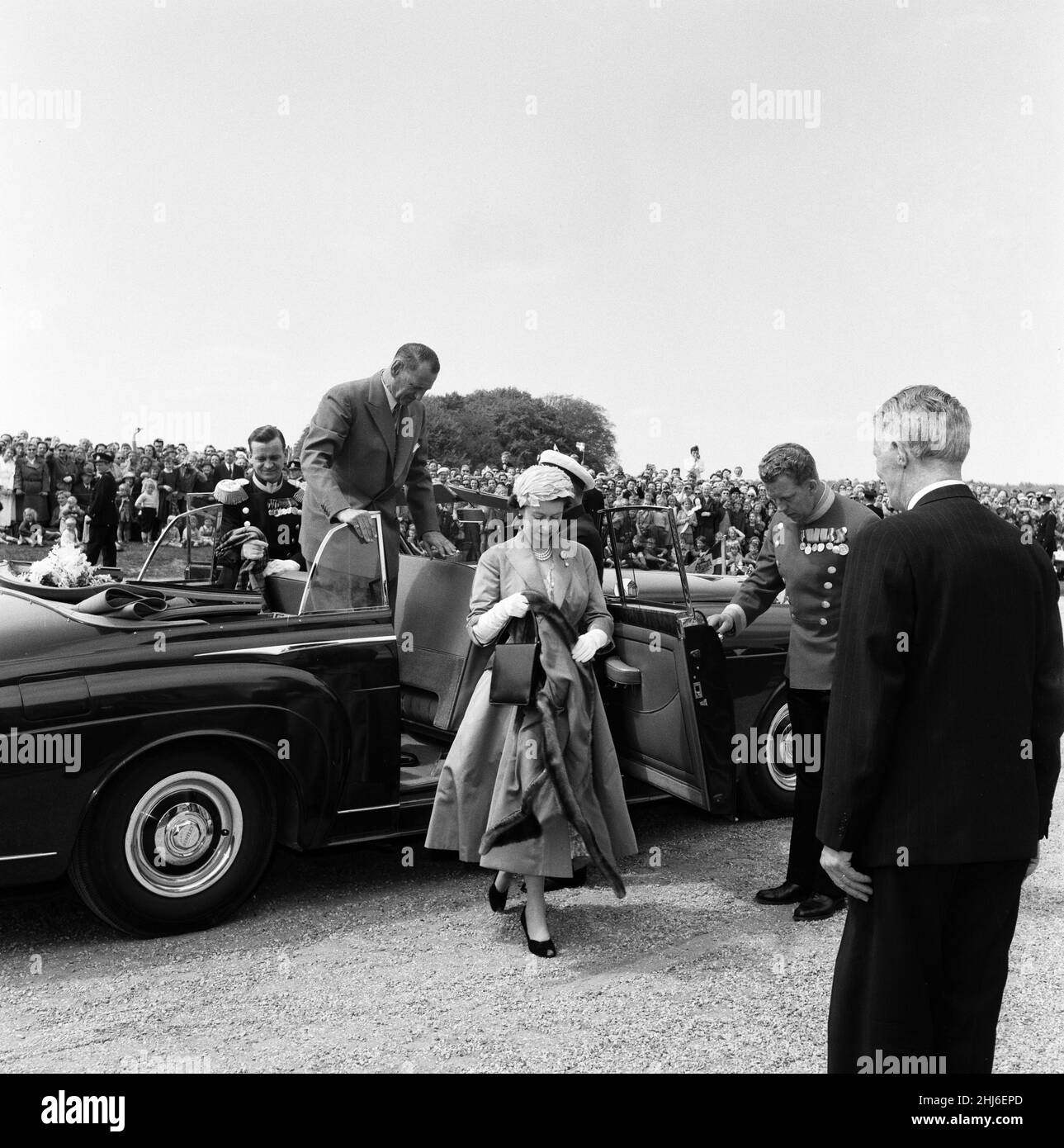 Königin Elizabeth II. Und Prinz Philip, Herzog von Edinburgh, besuchen Dänemark. Königin Elizabeth II. Hält ihren Umhang über ihren Arm, nachdem sie aus ihrem Auto gesteigt war, als sie im Jagdschloss ankam, wo sie zu Mittag gegessen hatte. 23rd Mai 1957. Stockfoto