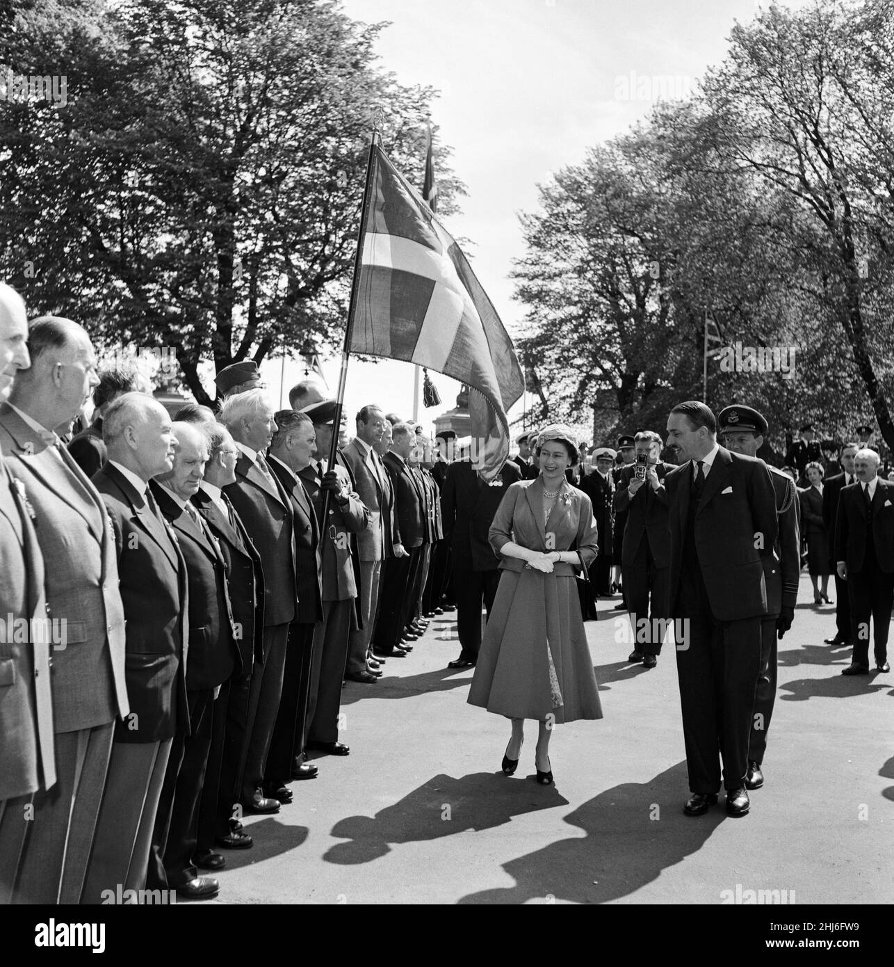 Königin Elizabeth II. Und Prinz Philip, Herzog von Edinburgh, besuchen Dänemark. Die Königin bei einer Parade ehemaliger Soldaten in der englischen Kirche St. Alban's in Kopenhagen. Mit ihr ist der britische Botschafter Sir Roderick Barclay. 23rd Mai 1957. Stockfoto