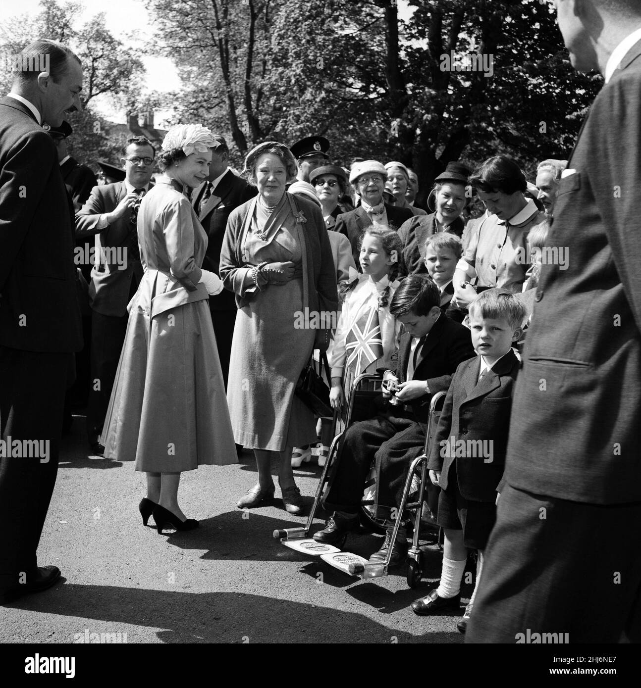 Königin Elizabeth II. Und Prinz Philip, Herzog von Edinburgh, besuchen Dänemark. Beim Besuch einer englischsprachigen Kirche wartet die Königin darauf, dass der Junge im Rollstuhl das nimmt, was er hofft, das Bild eines Lebens zu sein. Der Junge ist Jimmy Morrow, Sohn des britischen Naval Attache. 23rd Mai 1957. Stockfoto