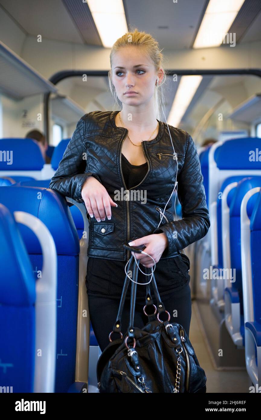 Rotterdam, Niederlande. Porträt einer jungen erwachsenen, blonden und modischen Frau, die mit dem Intercity-Zug vom Hauptbahnhof nach Hause pendelt. Stockfoto