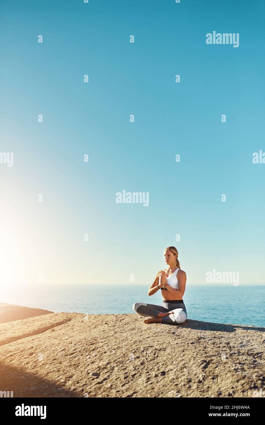 Jeder sollte Yoga praktizieren. Aufnahme einer jungen Frau, die am Strand Yoga macht. Stockfoto